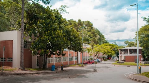 Fachada da Faculdade de Fisioterapia em Juiz de Fora, cercada por árvores.